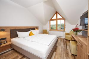 - une chambre avec un grand lit blanc et une fenêtre dans l'établissement Wo der Hahn kräht, à Flein