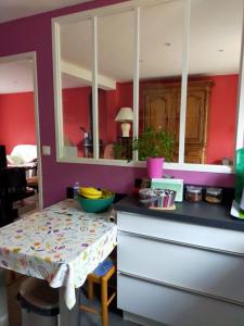 a kitchen with red walls and a table with a counter at House with garden in Biarritz - quiet area in Biarritz