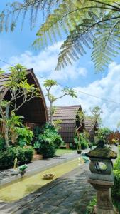 a garden with a building and a stone walk way at Umah lumbung bedugul in Bedugul