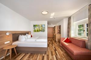 une chambre d'hôtel avec un lit et un canapé dans l'établissement Wo der Hahn kräht, à Flein