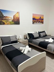 - une chambre avec 2 lits et un tableau mural dans l'établissement Palmira's Rome Sweet Home, à Rome
