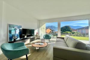 Una sala de estar con un sofá y sillas y una ventana grande. en Condominio Modern House, en Menaggio