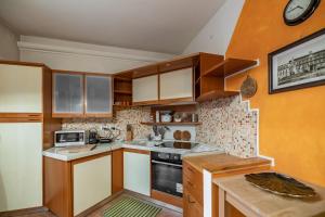 a kitchen with wooden cabinets and a stove top oven at Mestre da Luca Apartment con posto auto! in Mestre
