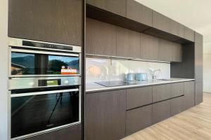 Il comprend une cuisine équipée d'un four micro-ondes et d'un évier. dans l'établissement Condominio Modern House, à Menaggio