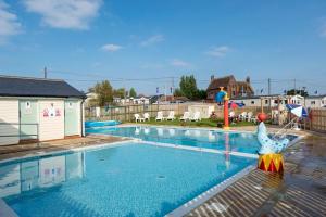 a large swimming pool with a inflatableentityituresigunigunigunigunigunigun at Vista Caravan Hire in Seasalter