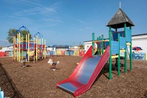 a playground with a red slide in a park at Vista Caravan Hire in Seasalter