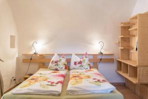 una camera con due letti con cuscini e scaffali di Moserhof Ferienwohnung Sunnseit a Sarentino (Sarntal)