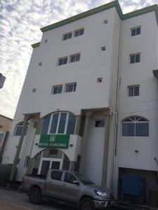 un camion argento parcheggiato di fronte a un edificio di Hotel El Medina a Nouadhibou