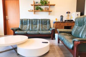 - un salon avec deux canapés et une table dans l'établissement Palm Tree Villa, à Seogwipo