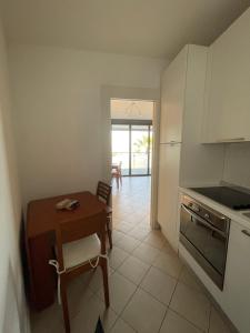a kitchen with a table and a small table and a table and a table at San Lorenzo Marina Apartment in San Lorenzo al Mare