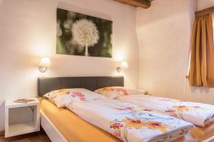 a bedroom with two beds and a picture on the wall at Moserhof Ferienwohnung Schartblick in Sarntal