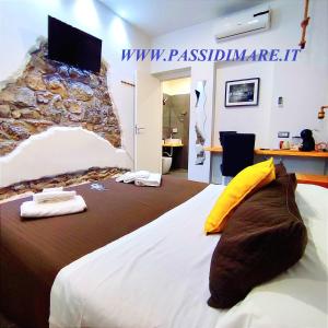 Un dormitorio con una cama grande con un televisor en la pared. en Passi di Mare Rooms, en Giardini Naxos