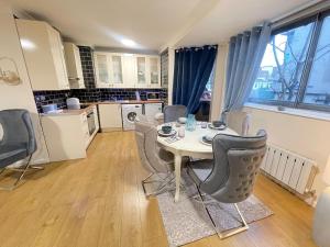 ein Esszimmer mit einem Tisch und Stühlen in einer Küche in der Unterkunft The Sherborne Residence in London