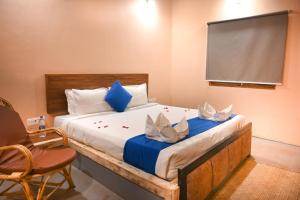 a bedroom with a bed with blue and white pillows at Amadi Beach Front Resort in Mandrem