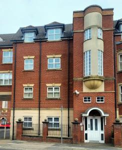 einem roten Backsteingebäude mit einer weißen Tür in der Unterkunft 1 Merchants Gate - 2 bedroom, city apartment with private parking in York