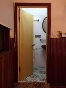 a door leading to a bathroom with a toilet at Dimocrata in Phnom Penh