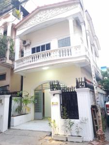 een wit huis met een balkon erop bij Dimocrata in Phnom Penh