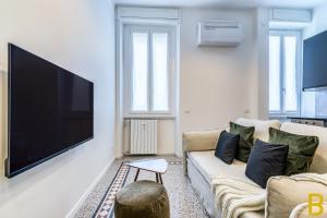 un salon avec une grande télévision murale à écran plat dans l'établissement BePlace Apartments in Fiera, à Milan