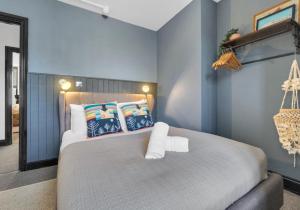 Olive Apartment Three By My Getaways في برايتون أند هوف: غرفة نوم بسرير كبير بجدران زرقاء