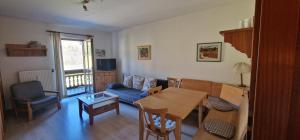 Una sala de estar con una mesa y un sofá azul. en ciao-aschau Gschwendtnerhof Ap20 Bunk, en Aschau