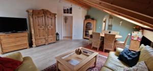 a living room with a couch and a tv at ciao-aschau FeWo Bergsonne Kurtenbach in Aschau