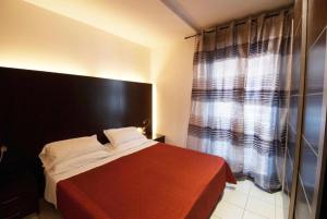 a bedroom with a red bed and a window at Residence Domus in Rimini