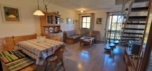 a living room with a table and chairs and a staircase at ciao-aschau Gschwendtnerhof Ap18 SchölzkeV in Aschau