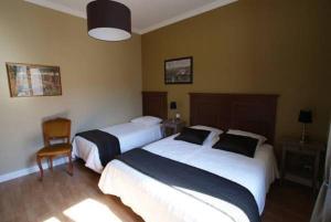 una camera d'albergo con due letti e una sedia di Carcassonne Guesthouse a Carcassonne