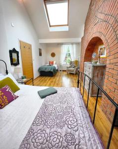 1 dormitorio con cama y pared de ladrillo en 2 Bedroom Apartment in Central Location, en Bangor
