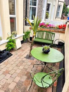 a green table and chairs on a patio at 2 Bedroom Apartment in Central Location in Bangor