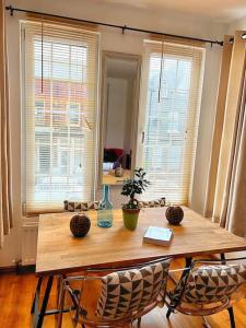 una mesa de comedor con sillas y un jarrón. en 2 Bedroom Apartment in Central Location, en Bangor