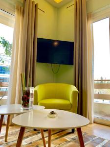 Olympian Zeus apartments في أثينا: غرفة معيشة فيها كرسي اصفر وطاولة