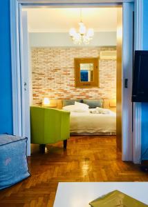 Olympian Zeus apartments في أثينا: غرفة معيشة مع سرير وكرسي أخضر