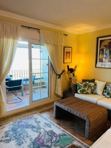 ein Wohnzimmer mit einem Sofa und einem Balkon in der Unterkunft Marina II apartment in Huelva