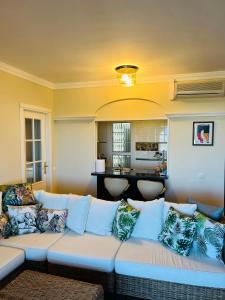 ein Wohnzimmer mit einer weißen Couch mit Kissen in der Unterkunft Marina II apartment in Huelva