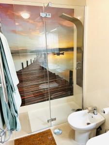 ein Badezimmer mit einer Dusche und einem Gemälde eines Piers in der Unterkunft Marina II apartment in Huelva