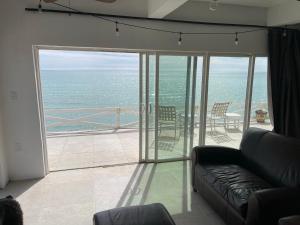 a living room with a couch and a view of the ocean at Jardin Del Mar in Puerto Pe&ntilde;asco