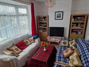 a living room with two couches and a tv at Bob's House quiet retreat with large shared garden in Loughborough
