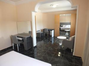 een kamer met een tafel en stoelen en een slaapkamer bij Hotel El Medina in Nouadhibou