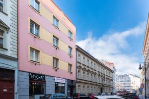 布拉格的住宿－水晶公寓，城市街道上的粉红色和黄色建筑
