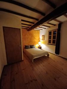 ein Schlafzimmer mit einem Bett und einer Tür in einem Zimmer in der Unterkunft Maison dans le sud du Gers 