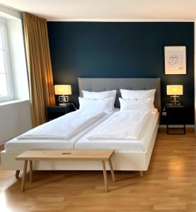 ein großes weißes Bett in einem Zimmer mit zwei Lampen in der Unterkunft DK Hotel Deutscher Kaiser in Heidelberg