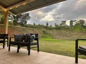 - un banc avec des oreillers sur une terrasse offrant une vue sur un champ dans l'établissement Casa Armadillo, à Almirante