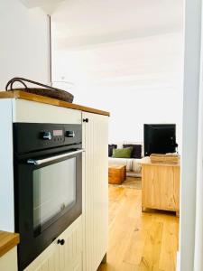 a kitchen with a stove and a living room at Stylisches Haus mit Garten in zentraler Lage in Wuppertal