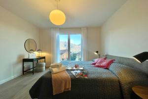 une chambre avec un lit et une grande fenêtre dans l'établissement Condominio Modern House, à Menaggio