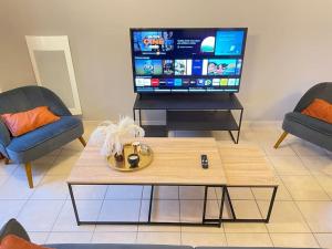 uma sala de estar com uma mesa de centro e uma televisão de ecrã plano em Havre de paix spa proche Amboise & châteaux de la Loire em Noizay