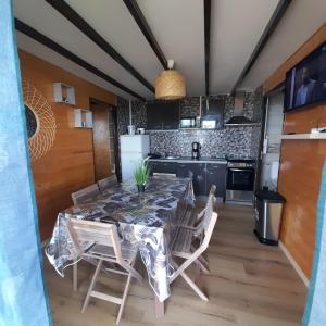 a dining room with a table and chairs in a kitchen at Ty kaz kryst'L in Le Tampon