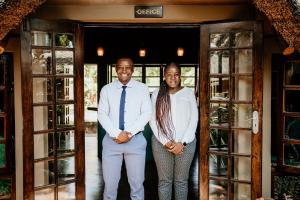 mężczyzna i kobieta stojący w drzwiach w obiekcie Amanzi Lodge w mieście Harare