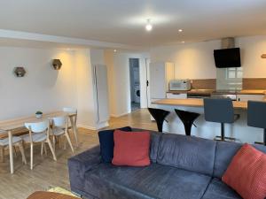 a living room with a couch and a kitchen at Bel Appartement Climatisé au cœur du village in Saint-Aubin