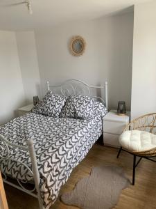 a bedroom with a bed with a black and white comforter at Bel Appartement Climatisé au cœur du village in Saint-Aubin